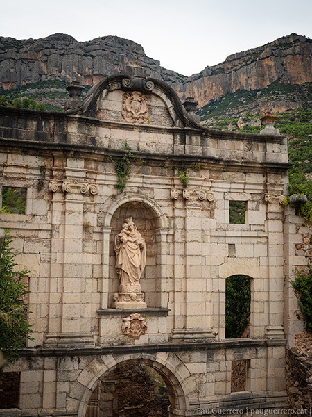 Façana neoclàssica (s. XVII) de la cartoixa d'Escaladei amb els cingles de Montsant al fons