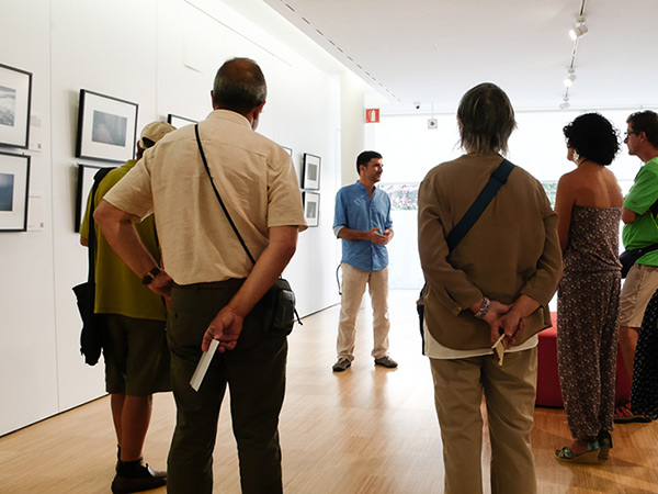 Pau Guerrero presentant el projecte fotogràfic *Paisatge i llegenda del comte Arnau* durant la seva exposició a la Biblioteca Carles Rahola de Girona