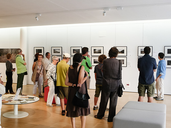 Pau Guerrero presentant el projecte fotogràfic *Paisatge i llegenda del comte Arnau* durant la seva exposició a la Biblioteca Carles Rahola de Girona