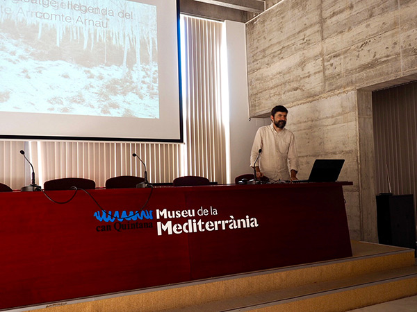 Pau Guerrero donant la xerrada *Paisatge i llegenda del comte Arnau* al Museu de la Mediterrania, durant el Festival de fotografia Mirades de Torroella de Montgrí