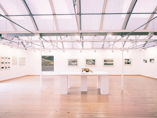 fotografia de l'exposició del projecte artístic Monegros al Km7 Espai d'Art José Luis Pascual. Pintura i dibuix de Jose M. Guerrero Medina i fotografia de paisatge de Pau Guerrero