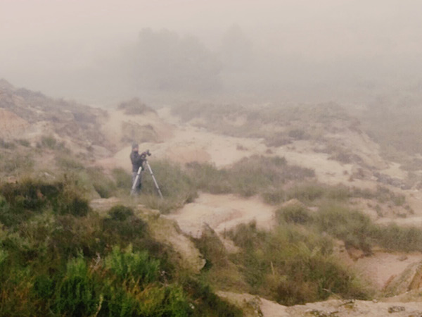 Pau Guerrero fotografiant el paisatge de Monegros envoltat de boira